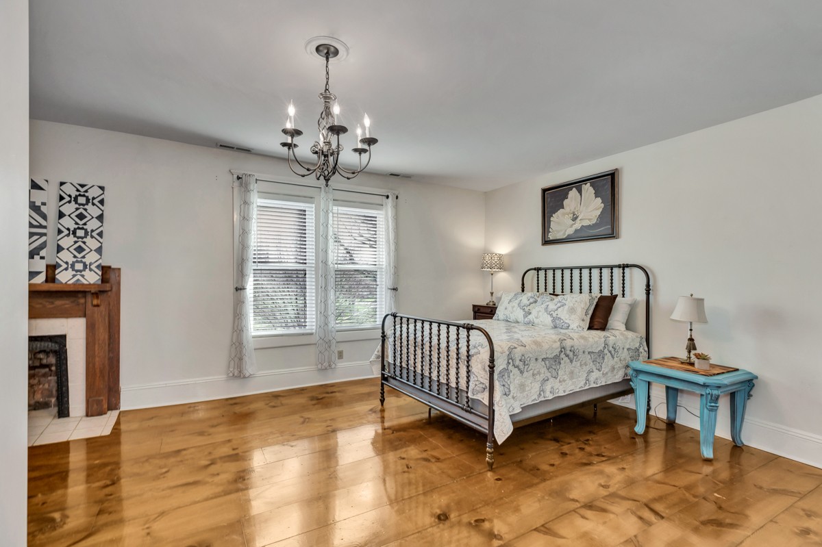 451 Wheelerton Road Dellrose, TN 38453 - Photo 19 of 34 a spacious bedroom with a bed and a chandelier