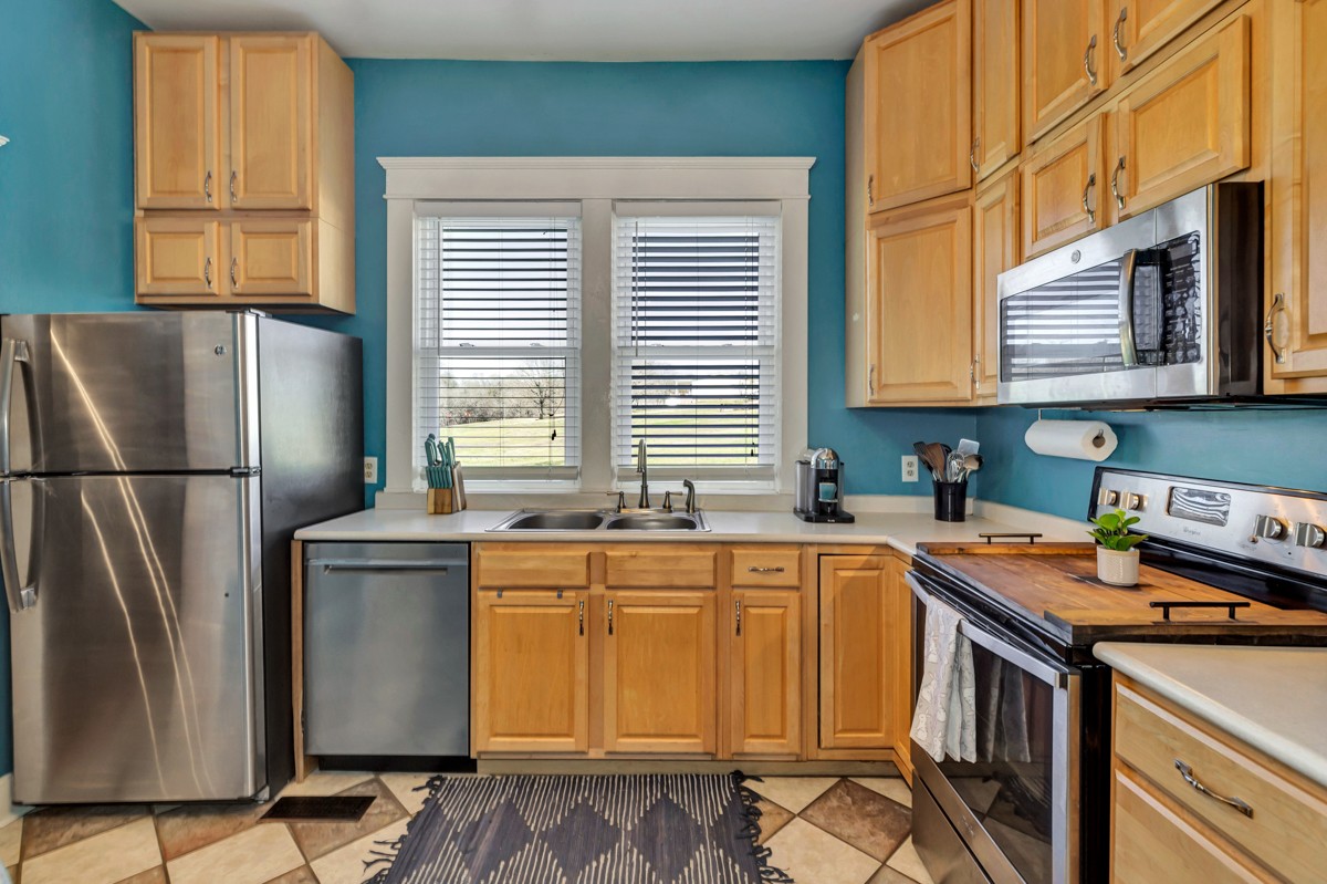 451 Wheelerton Road Dellrose, TN 38453 - Photo 8 of 34 a kitchen with stainless steel appliances granite countertop a refrigerator a sink a stove a washer dryer and a window