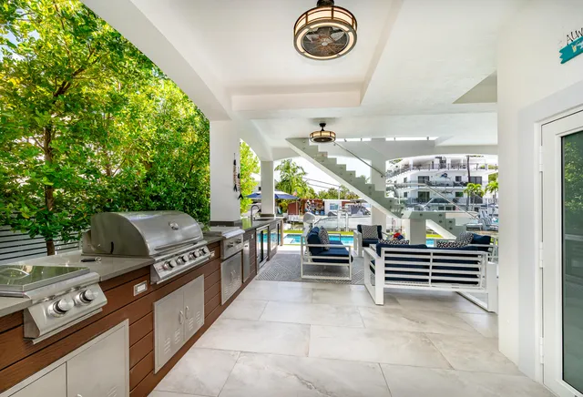 a kitchen with stainless steel appliances granite countertop a refrigerator a sink dishwasher a stove and white cabinets with wooden floor