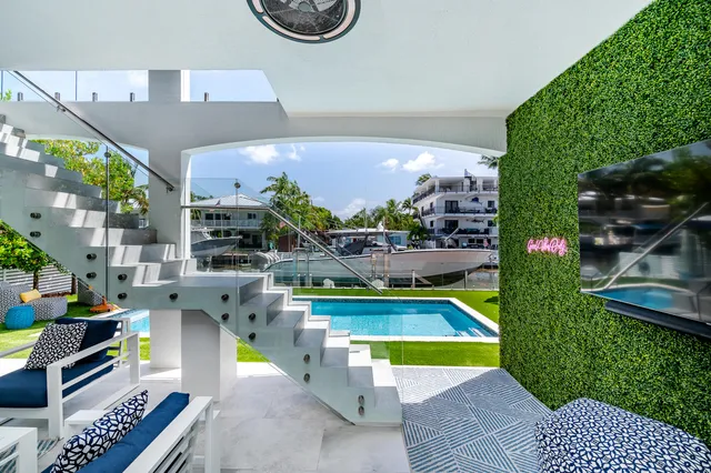 a kitchen with stainless steel appliances kitchen island granite countertop a table chairs and a view of living room