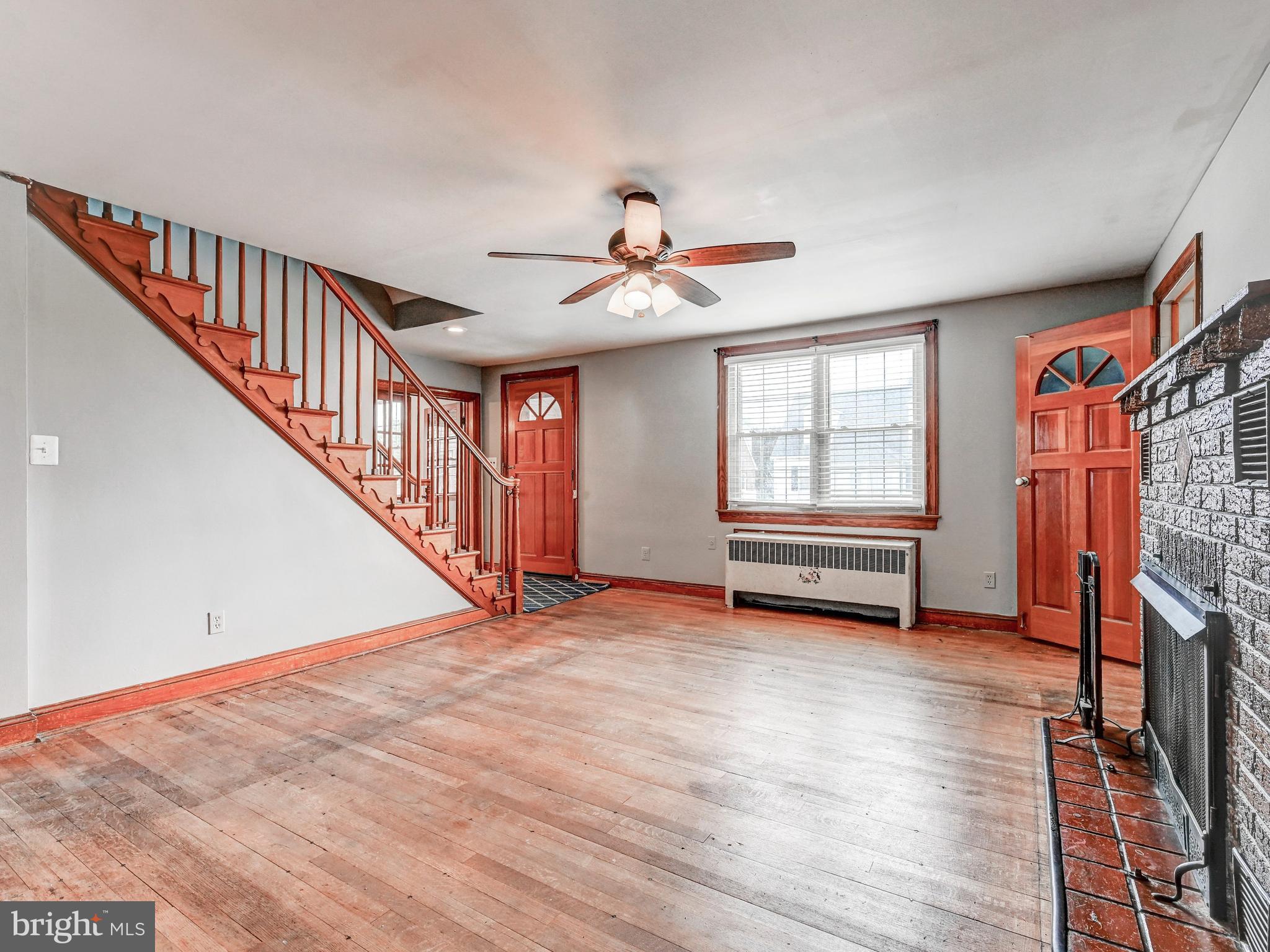 3206 Lynch Road Baltimore, MD 21219 - Photo 6 of 70 a view of a livingroom with wooden floor a ceiling fan and windows