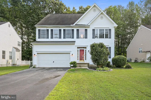 a front view of a house with a garden and plants