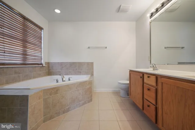 a bathroom with a tub sink and mirror