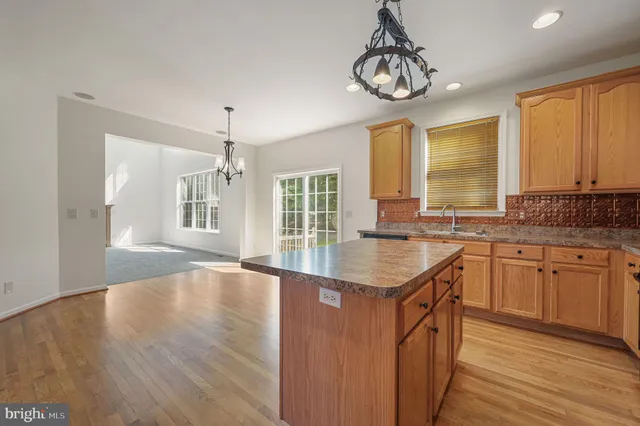 a kitchen with stainless steel appliances granite countertop a sink stove and wooden floor