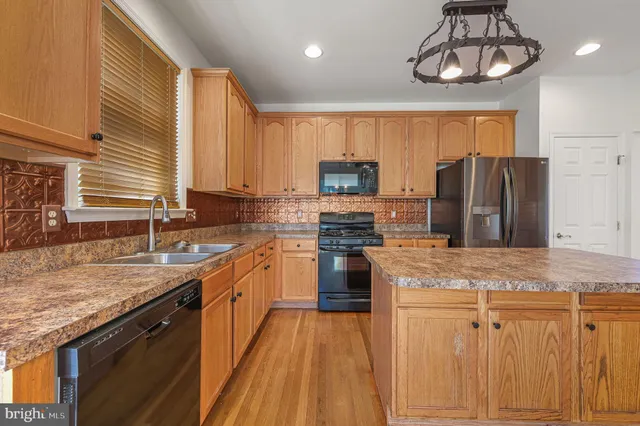 a kitchen with stainless steel appliances granite countertop a sink a stove and a refrigerator