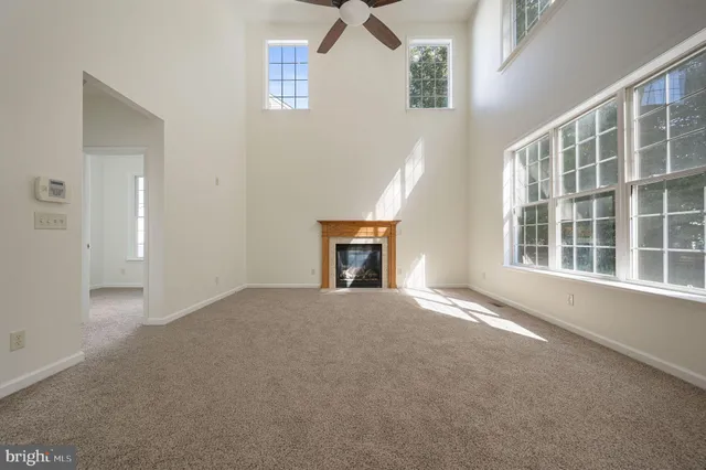 an empty room with windows and fireplace