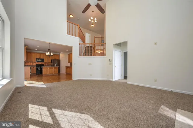 a view of a hallway with wooden floor and a living room