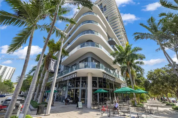 a front view of a building with a palm tree