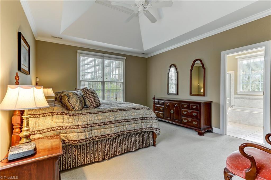 8183 Gray Leigh Court Oak Ridge, NC 27310 - Photo 14 of 29 The Master Bedroom has wall to wall carpeting, deep tray ceiling with ceiling fan, crown and base molding. Wood blinds on the window.