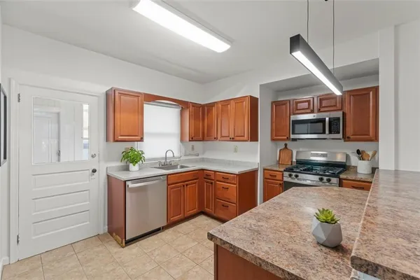 a kitchen with stainless steel appliances granite countertop sink stove and refrigerator