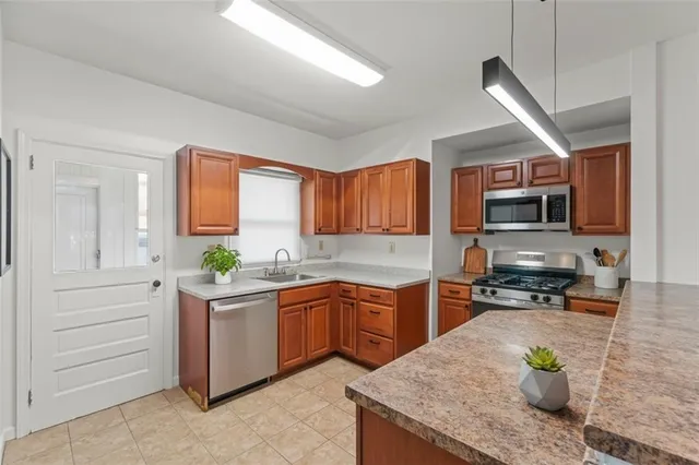 a kitchen with stainless steel appliances granite countertop sink stove and refrigerator