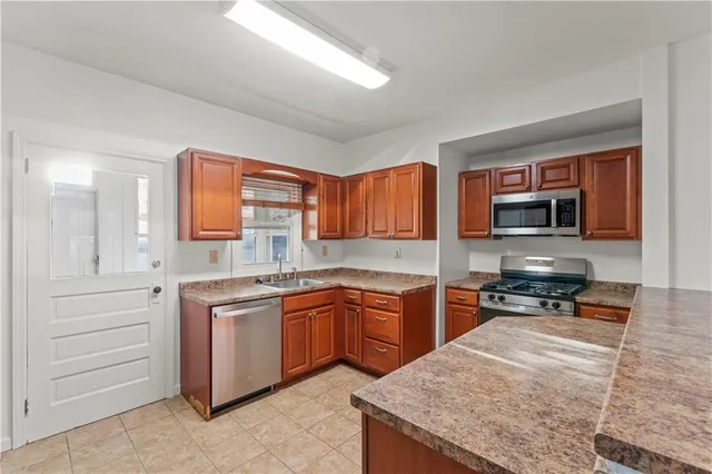 a kitchen with stainless steel appliances granite countertop a stove sink and microwave