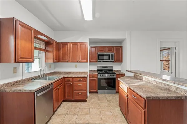 a kitchen with stainless steel appliances granite countertop a stove sink and cabinets