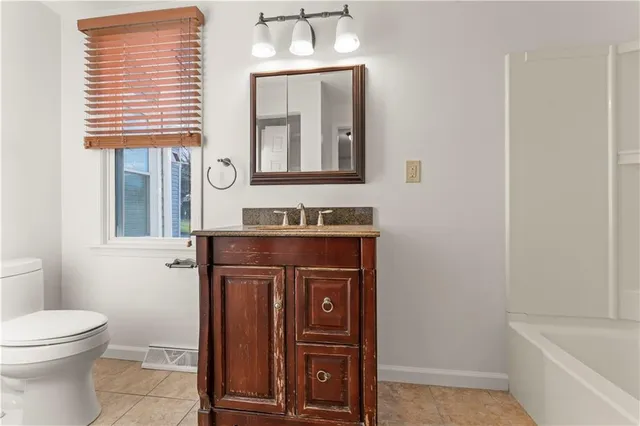 a bathroom with a sink a toilet and mirror