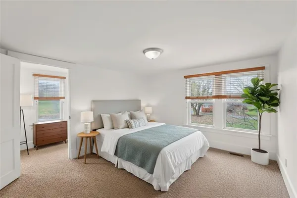 a bedroom with a bed and a potted plant