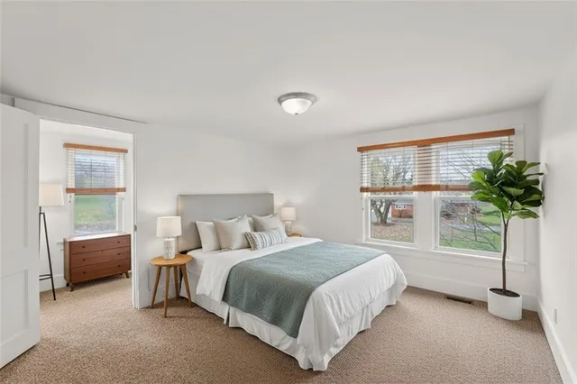 a bedroom with a bed and a potted plant