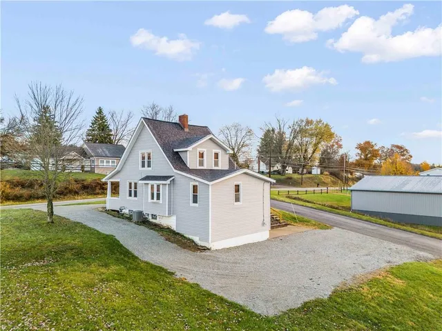a view of a house with a big yard and potted plants