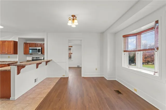 a view of a kitchen with wooden floor and a window