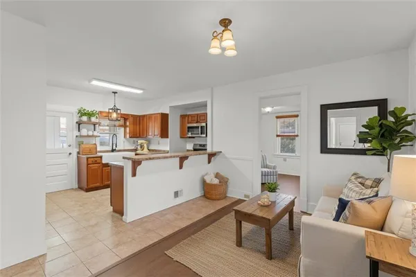 a living room with kitchen island furniture and a chandelier