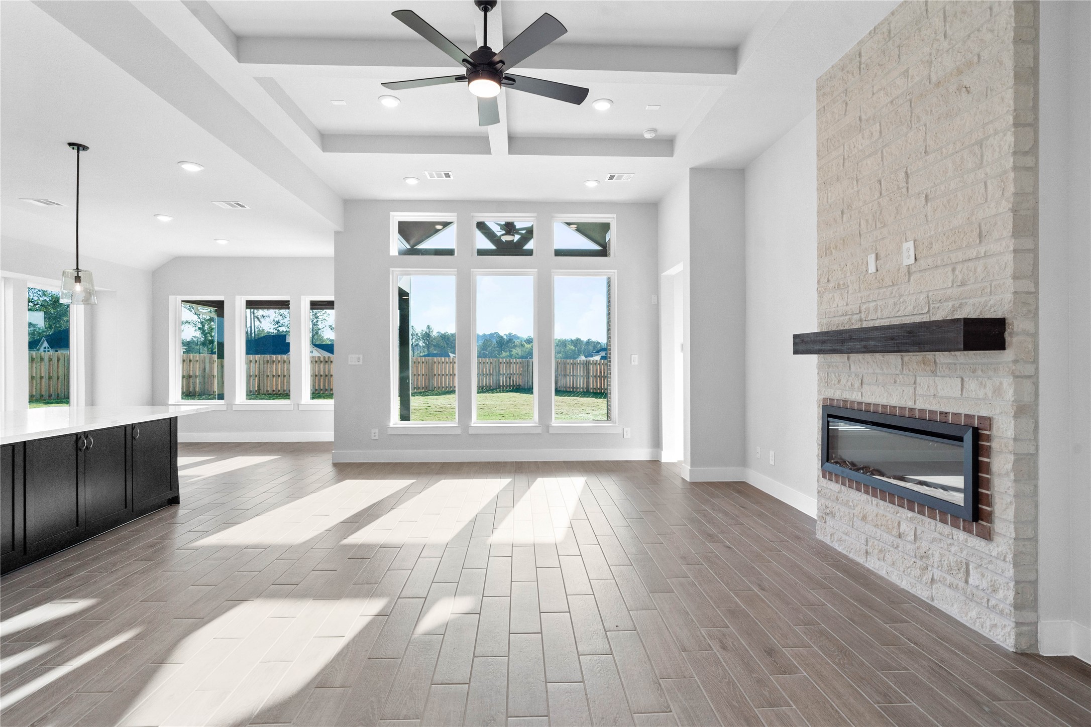 2114 Rowl Street Montgomery, TX 77316 - Photo 18 of 50 Bright and inviting living space featuring an open-concept design, soaring ceilings, and expansive windows that flood the room with natural light. Wide plank flooring and a seamless flow to the kitchen and dining areas create an ideal setting for both relaxed living and effortless entertaining.