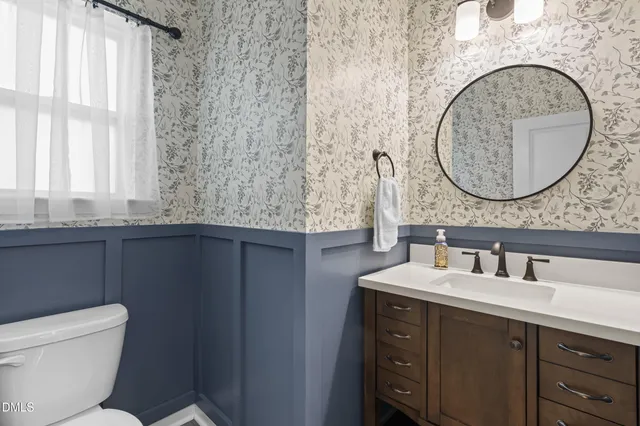 a bathroom with a granite countertop toilet sink and mirror