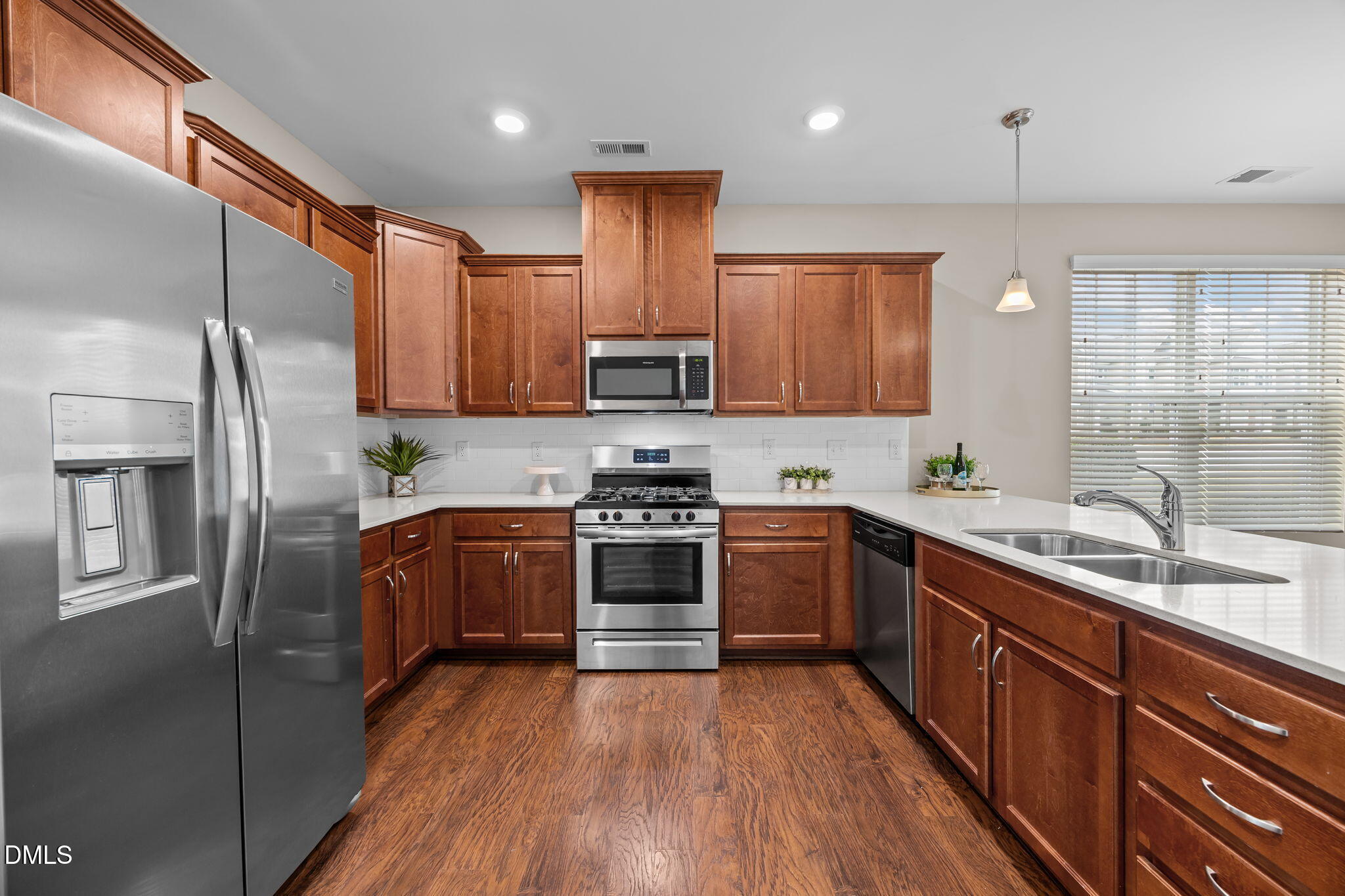 1001 Epiphany Road Morrisville, NC 27560 - Photo 5 of 39 a kitchen with stainless steel appliances granite countertop a refrigerator a sink dishwasher a stove with wooden floors and cabinets