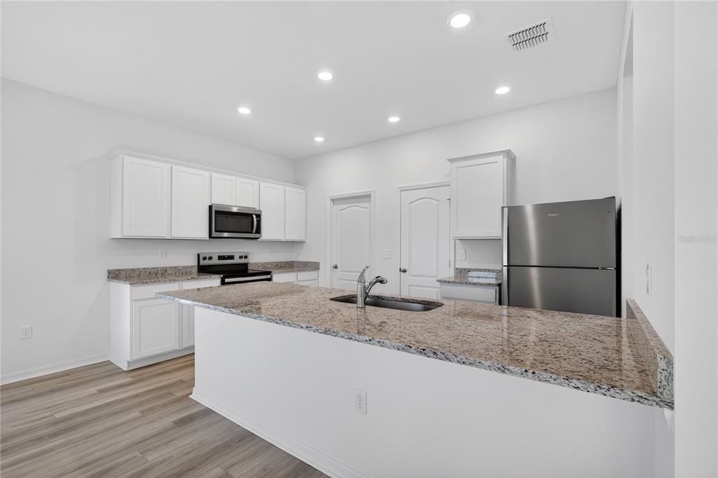 13430 Leaping Water Way Astatula, FL 34705 - Photo 15 of 55 a kitchen with sink a microwave and refrigerator