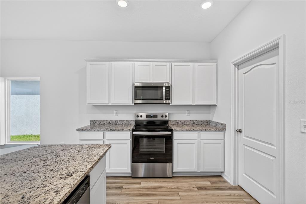 13430 Leaping Water Way Astatula, FL 34705 - Photo 16 of 55 a kitchen with granite countertop a stove sink and cabinets