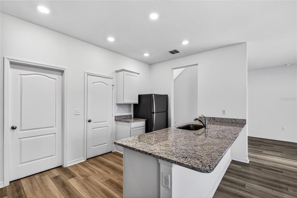 13430 Leaping Water Way Astatula, FL 34705 - Photo 17 of 55 a kitchen with kitchen island sink refrigerator and stove