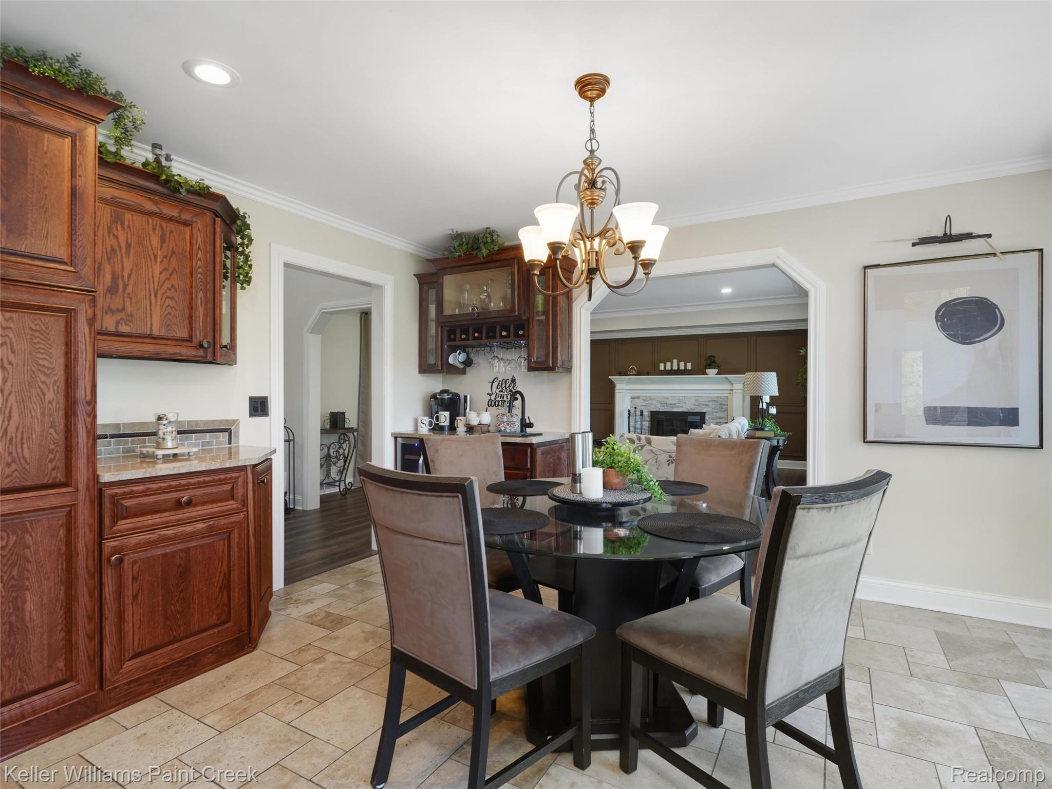 5813 36 Mile Road Romeo, MI 48065 - Photo 13 of 81 Dining area featuring tile flooring, a brass-finish chandelier, and a built-in wet bar with wood cabinetry