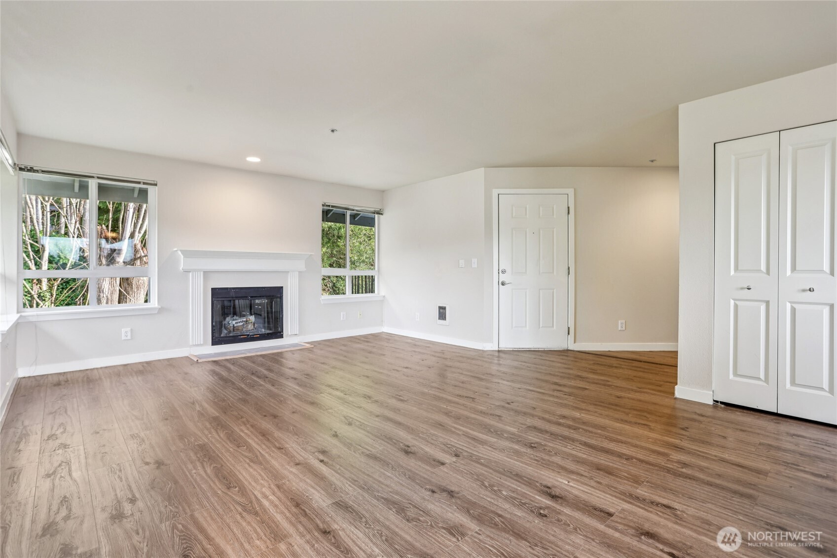 3927 243rd Place Southeast, Unit I304 Bothell, WA 98021 - Photo 6 of 28 an empty room with wooden floor fireplace and windows