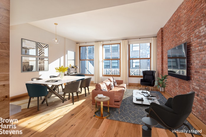a living room with couches a coffee table and a dining table with wooden floor