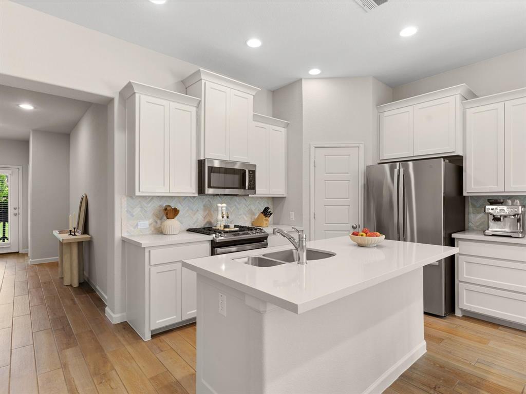 166 Palo Duro Bend Rhome, TX 76078 - Photo 12 of 40 Modern kitchen featuring granite countertops, stainless steel appliances, ample cabinetry, and a center island.
