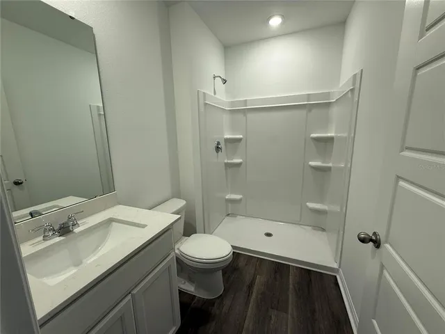 a bathroom with a sink a toilet and shower