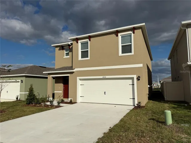 a view of a house with couches and potted plants