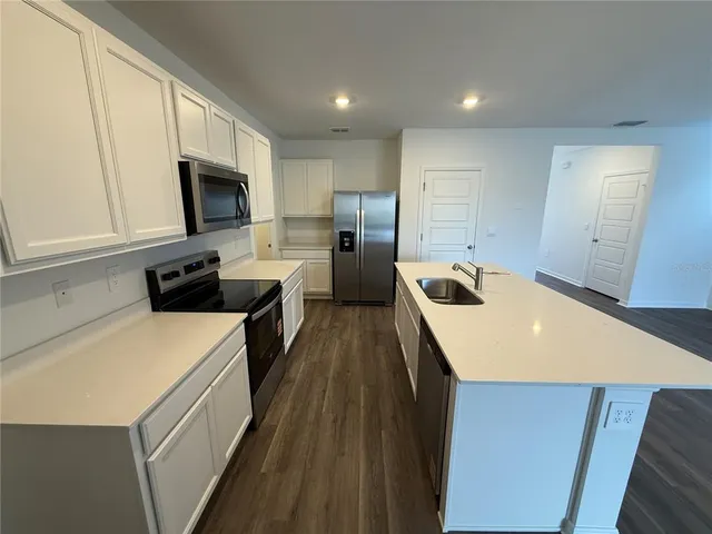 a kitchen that has a microwave a sink and a stove in it