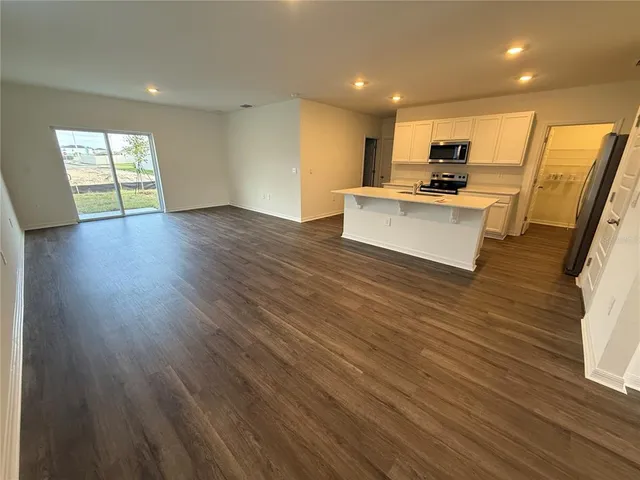 a view of kitchen with cabinets appliances and wooden floor