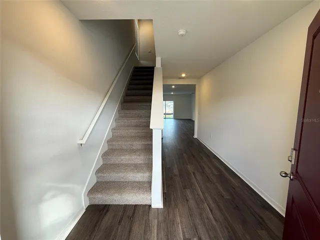 a view of entryway and hall with wooden floor
