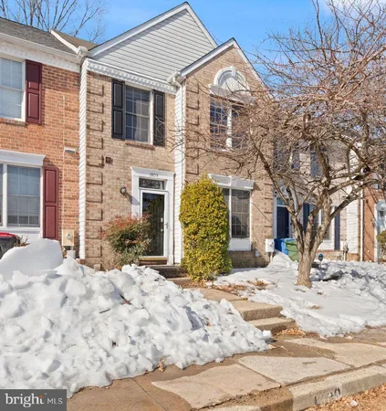 a view of a white house with a large tree