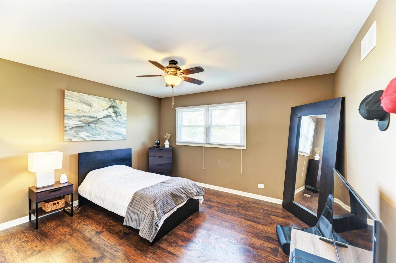 2210 Ridge Avenue Aurora, IL 60504 - Photo 21 of 29 a bedroom with a bed and a chandelier