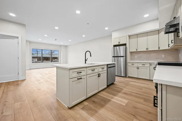 a kitchen with stainless steel appliances granite countertop a stove a sink and a refrigerator