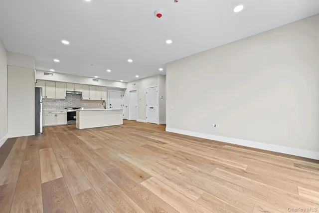 a view of kitchen with kitchen island a sink wooden floor and view living room