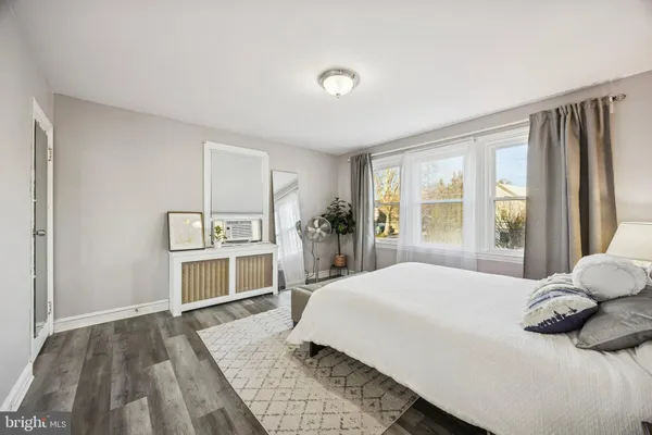 a spacious bedroom with a bed and a dresser