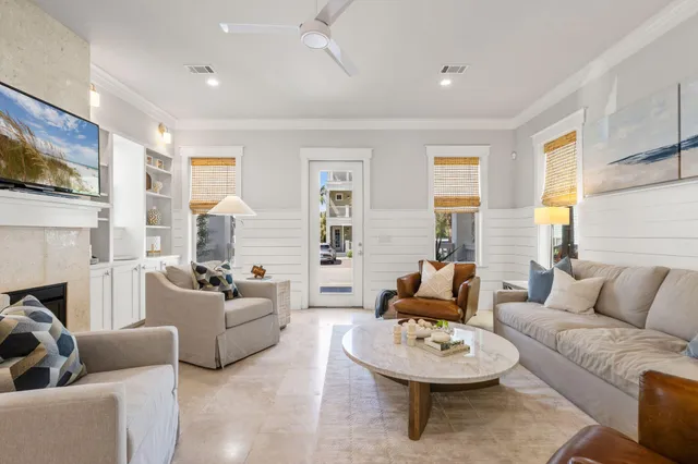 a living room with fireplace furniture and a view of kitchen