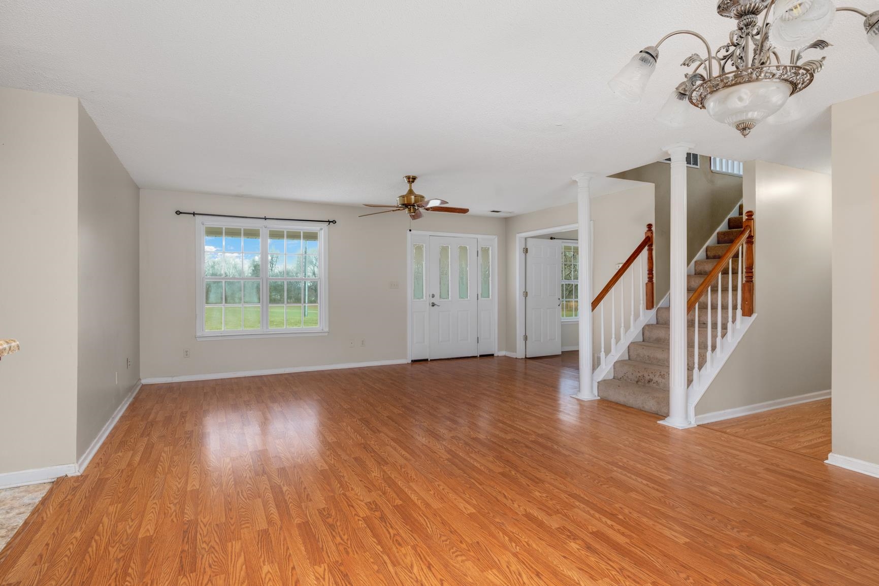 275 Morris Road Covington, TN 38019 - Photo 9 of 32 Unfurnished living room with light hardwood / wood-style flooring and ceiling fan with notable chandelier