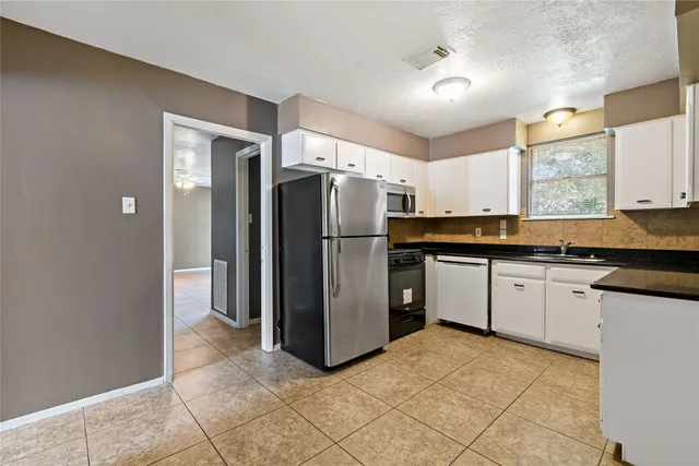 a kitchen with granite countertop a refrigerator and a sink