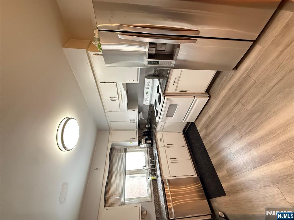 101 Orient Way, Unit 2C1 Rutherford, NJ 07070 - Photo 6 of 12 a kitchen with granite countertop white cabinets and stainless steel appliances