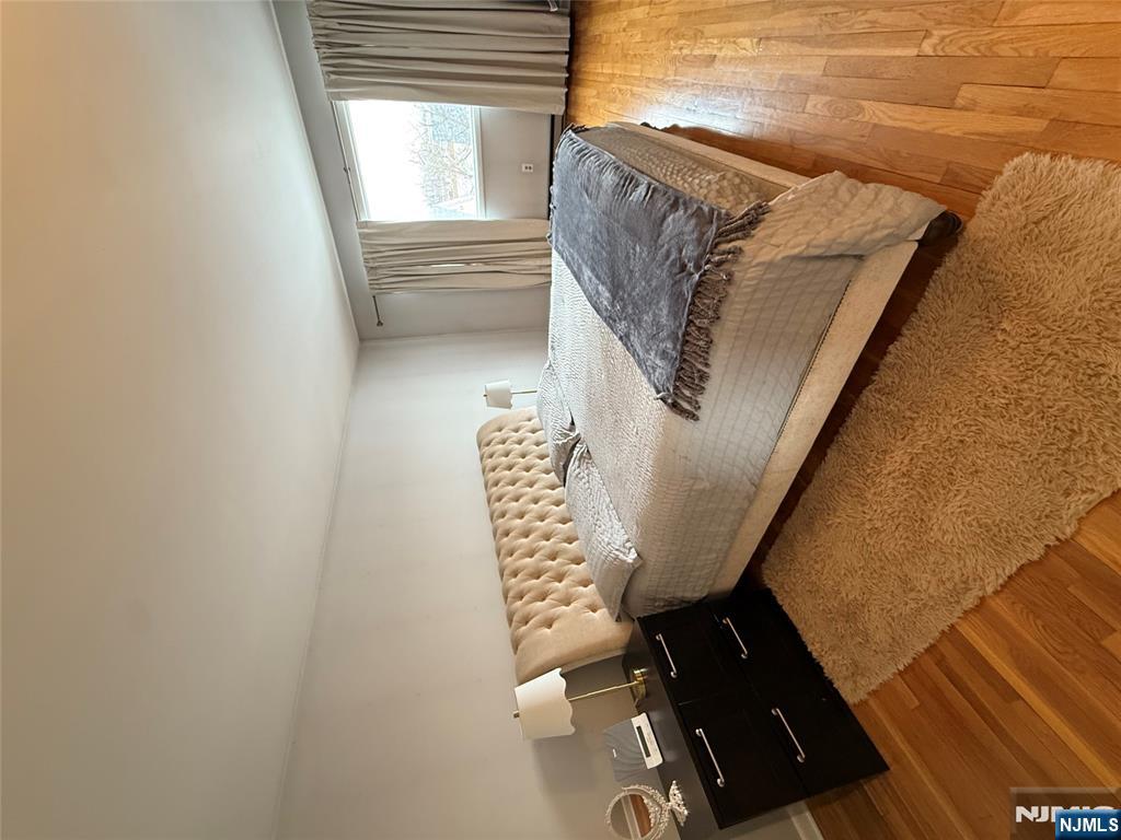 101 Orient Way, Unit 2C1 Rutherford, NJ 07070 - Photo 7 of 12 a bedroom with a bed and wooden floor