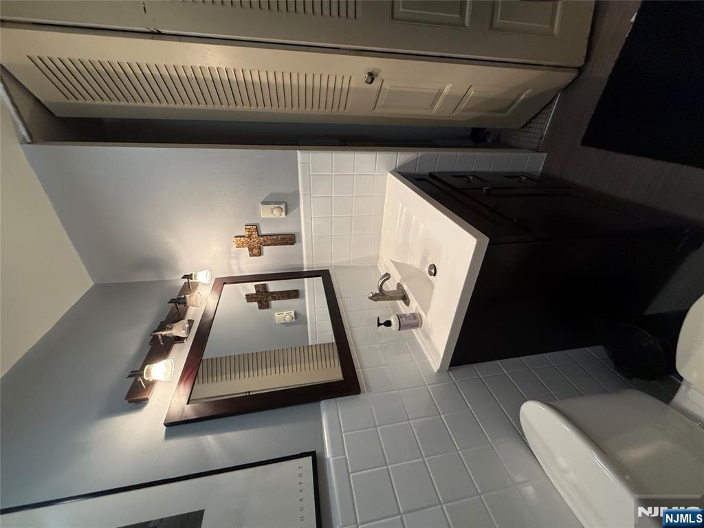 101 Orient Way, Unit 2C1 Rutherford, NJ 07070 - Photo 9 of 12 a bathroom with a sink toilet and mirror