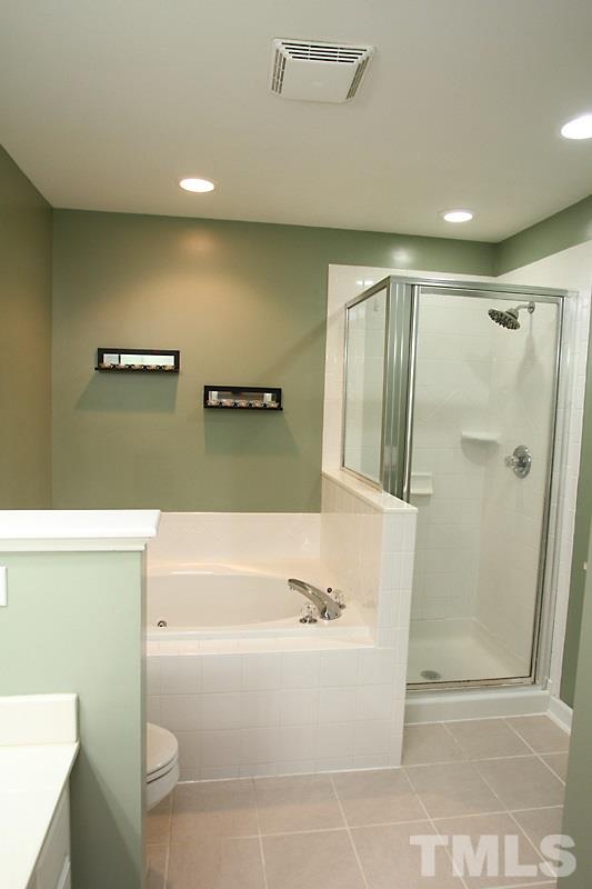 5425 Goldenglow Way Raleigh, NC 27606 - Photo 13 of 17 a bathroom with a tub a toilet and a shower